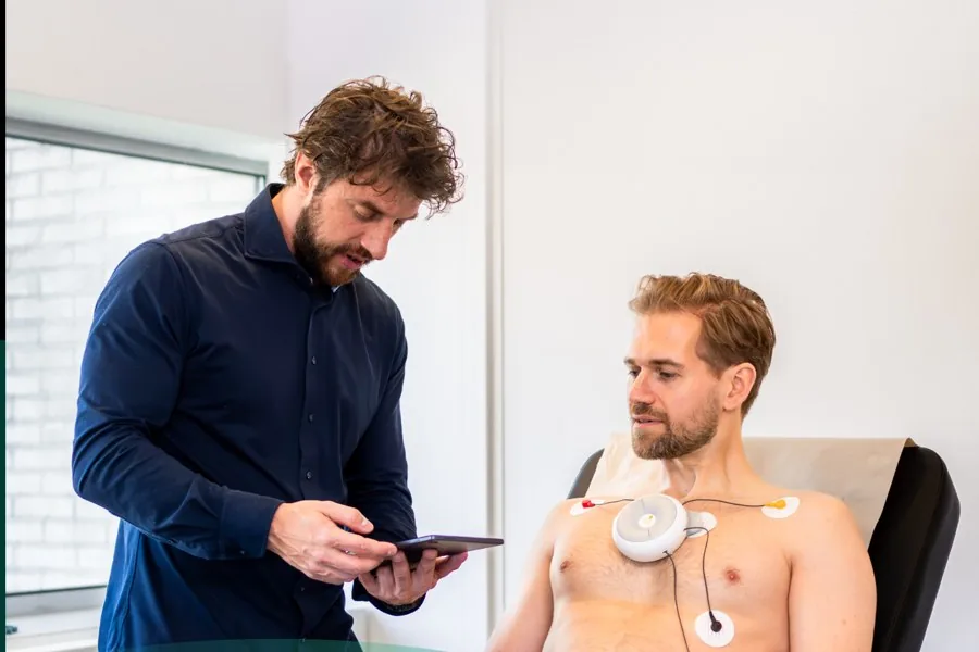 Een arts voert een ECG-meting uit bij een klant