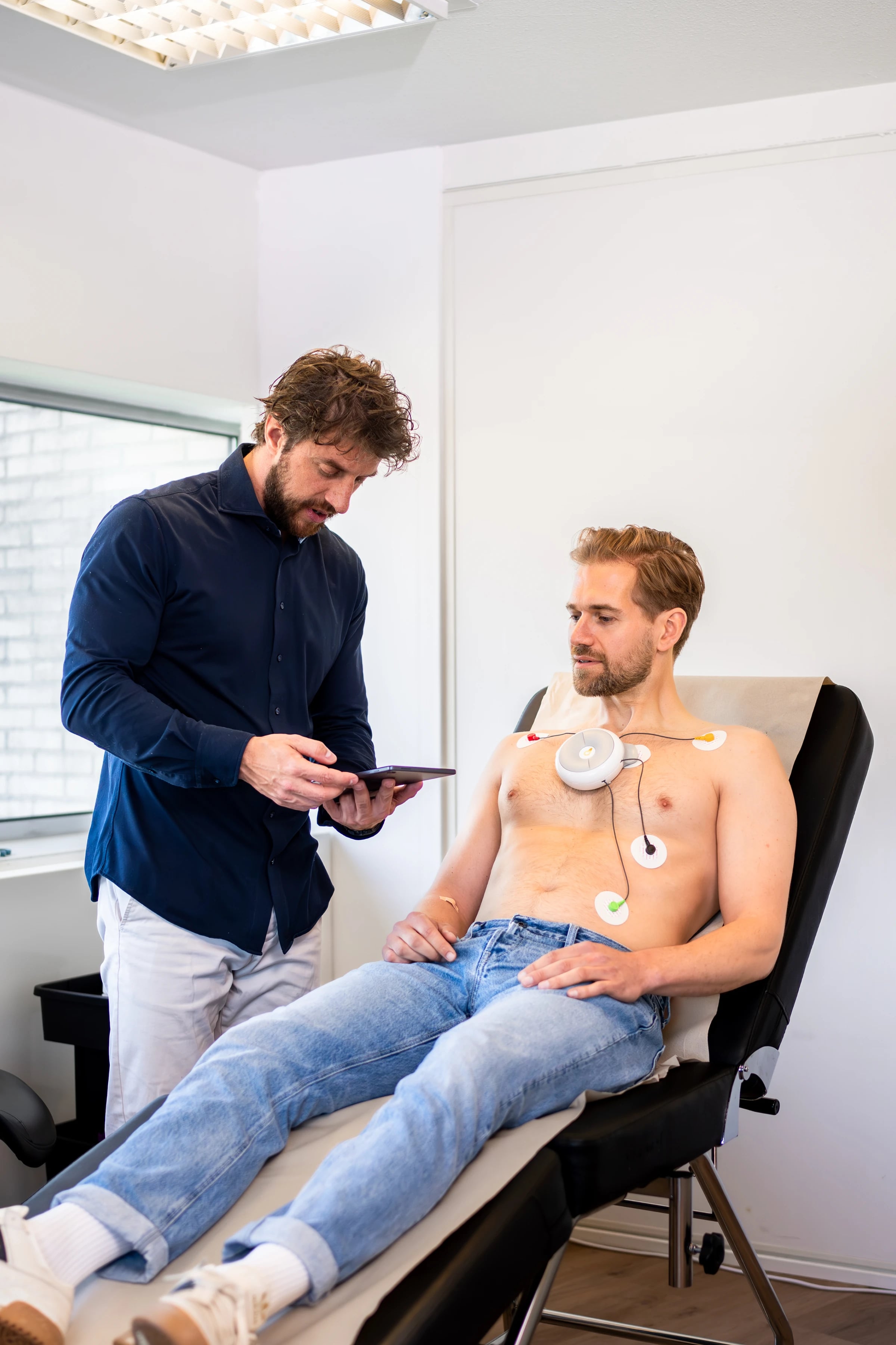Een arts voert een ECG-meting uit bij een klant